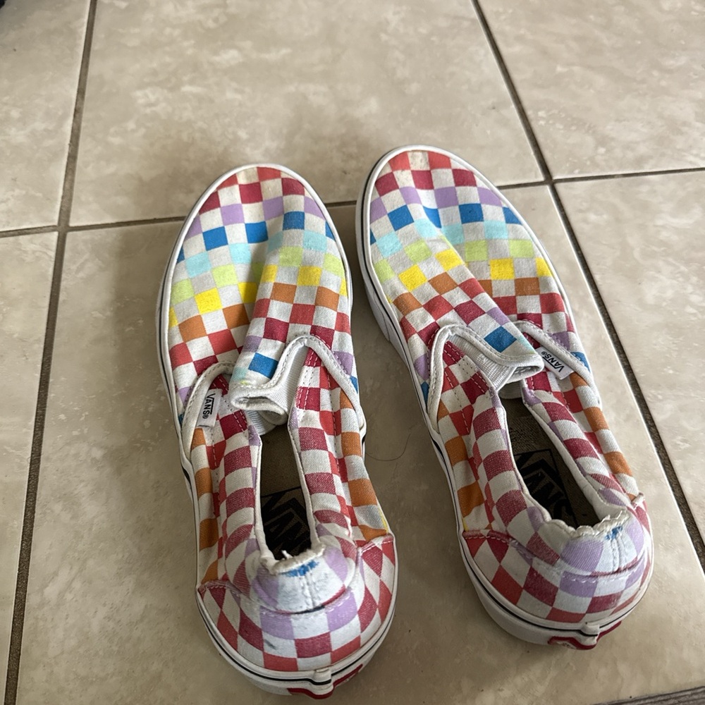 Rainbow checkered Vans slip-ons
